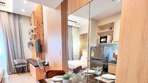 Een moderne hotelkamer met een eethoek, keuken en woonruimte.