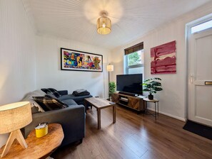 A living room with a sofa, TV, lamp, and artwork. - Cosy 2bed house in Reading (Reading)
