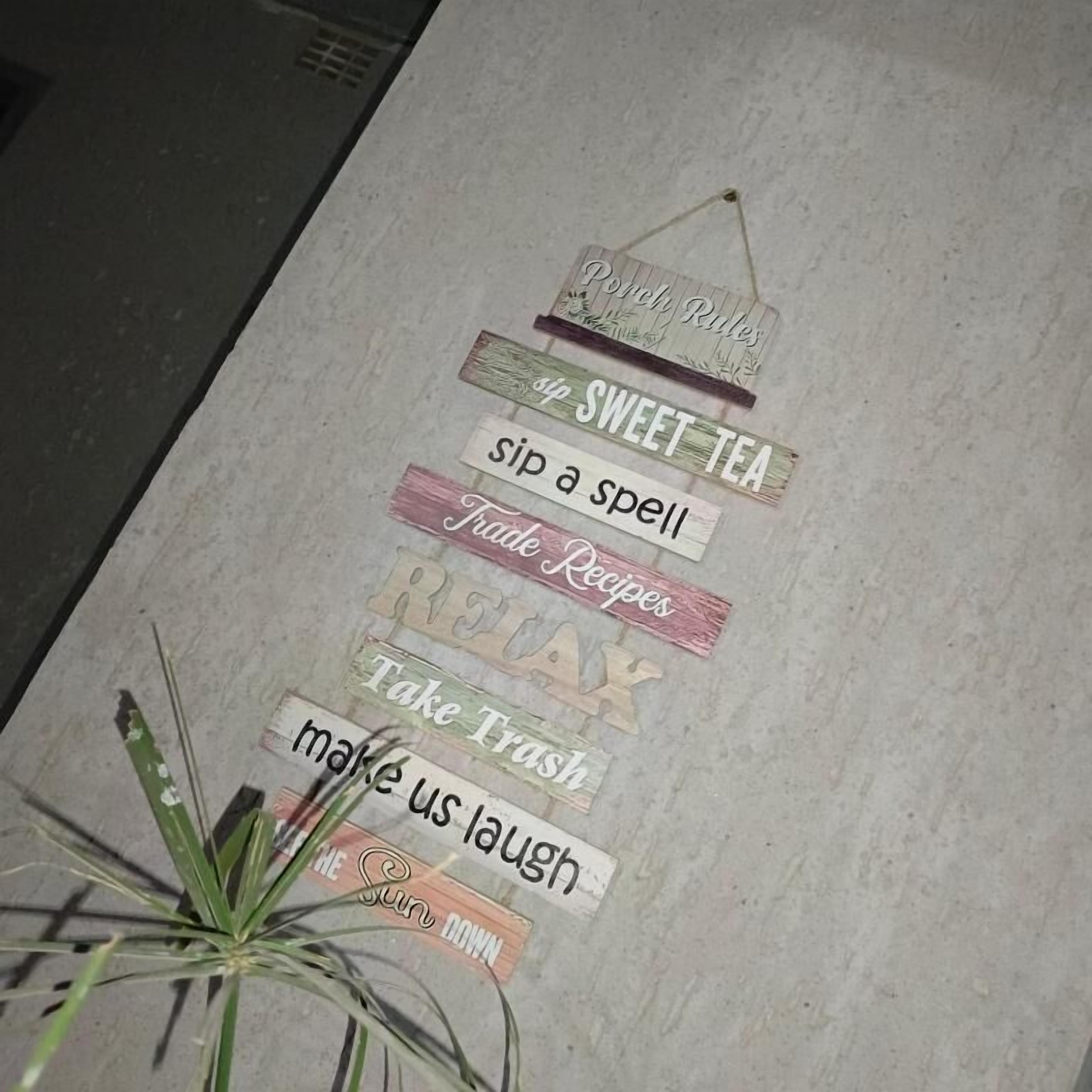 Una pared con varios letreros, incluyendo 'Sip Sweet Tea', 'Take Trash' y 'Make Us Laugh'.