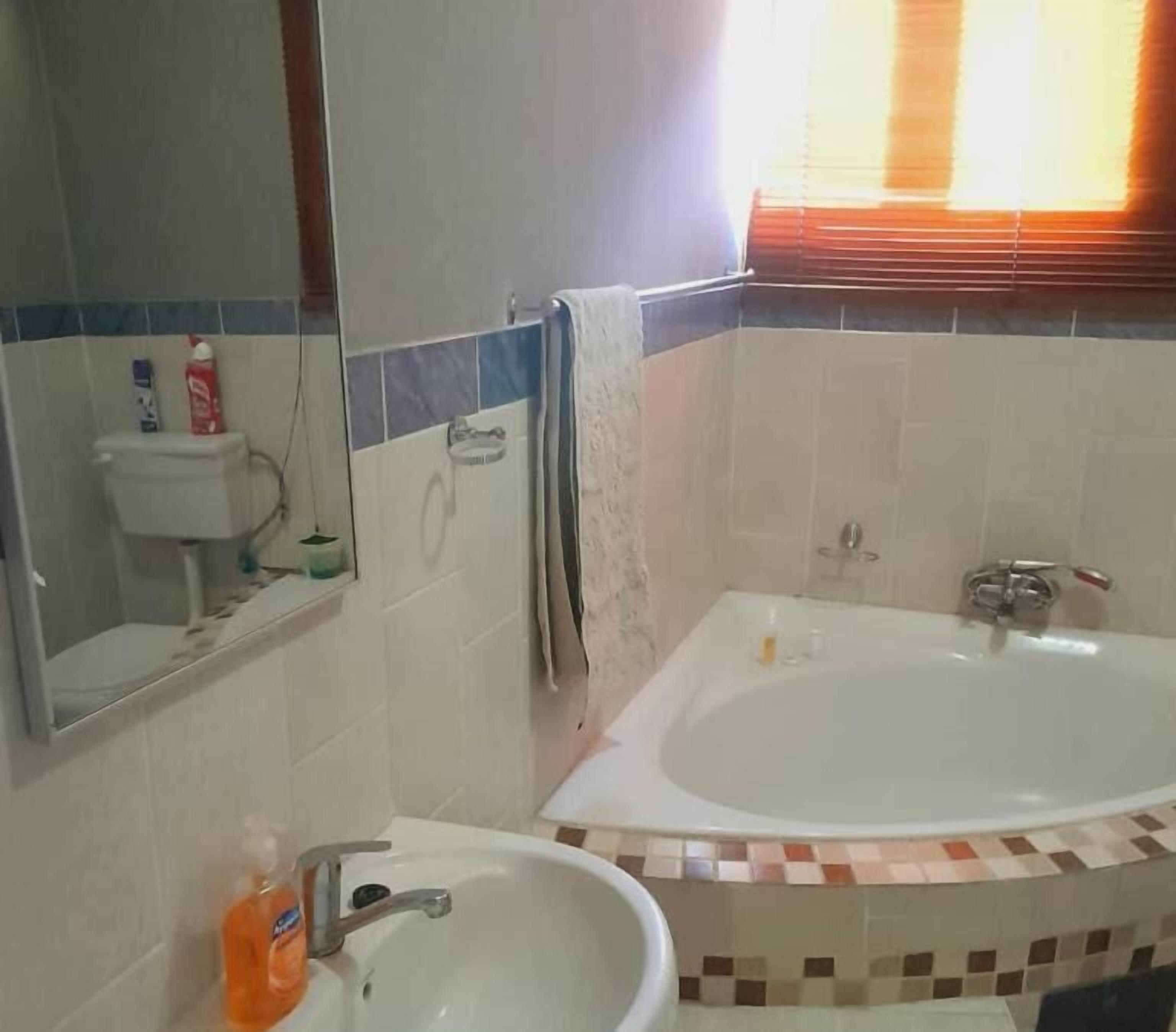 Ein Badezimmer mit einer Badewanne, einem Waschbecken, einer Toilette und einem Spiegel.