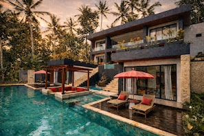 A modern two-story building with a pool, outdoor seating, and tropical vegetation. - Oran Villa Bali (Tampaksiring)