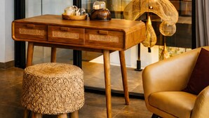 A modern interior with a wooden table, a woven ottoman, a leather sofa, and pendant lighting. - Oran Villa Bali (Tampaksiring)