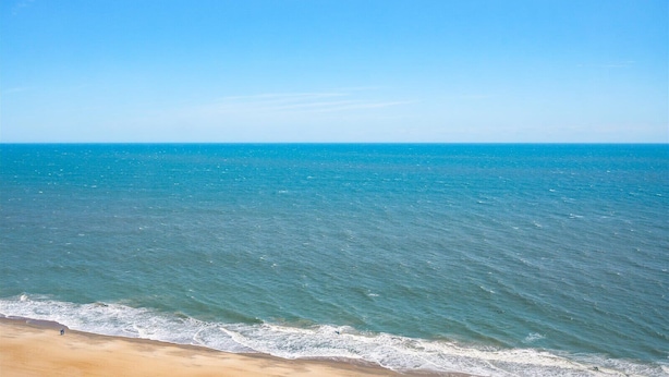 Ein Strand mit klarem, blauem Wasser und sandigem Ufer.