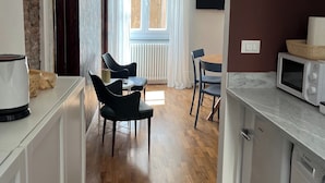 Una cocina moderna con microondas, lavavajillas Bosch y una zona de comedor con sillas y mesa.