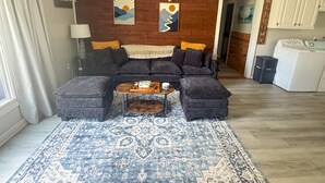 A living room with a sofa set, a coffee table, and a patterned rug. - Beautiful 2-bedroom cottage with AC in charming Lanexa (Lanexa)