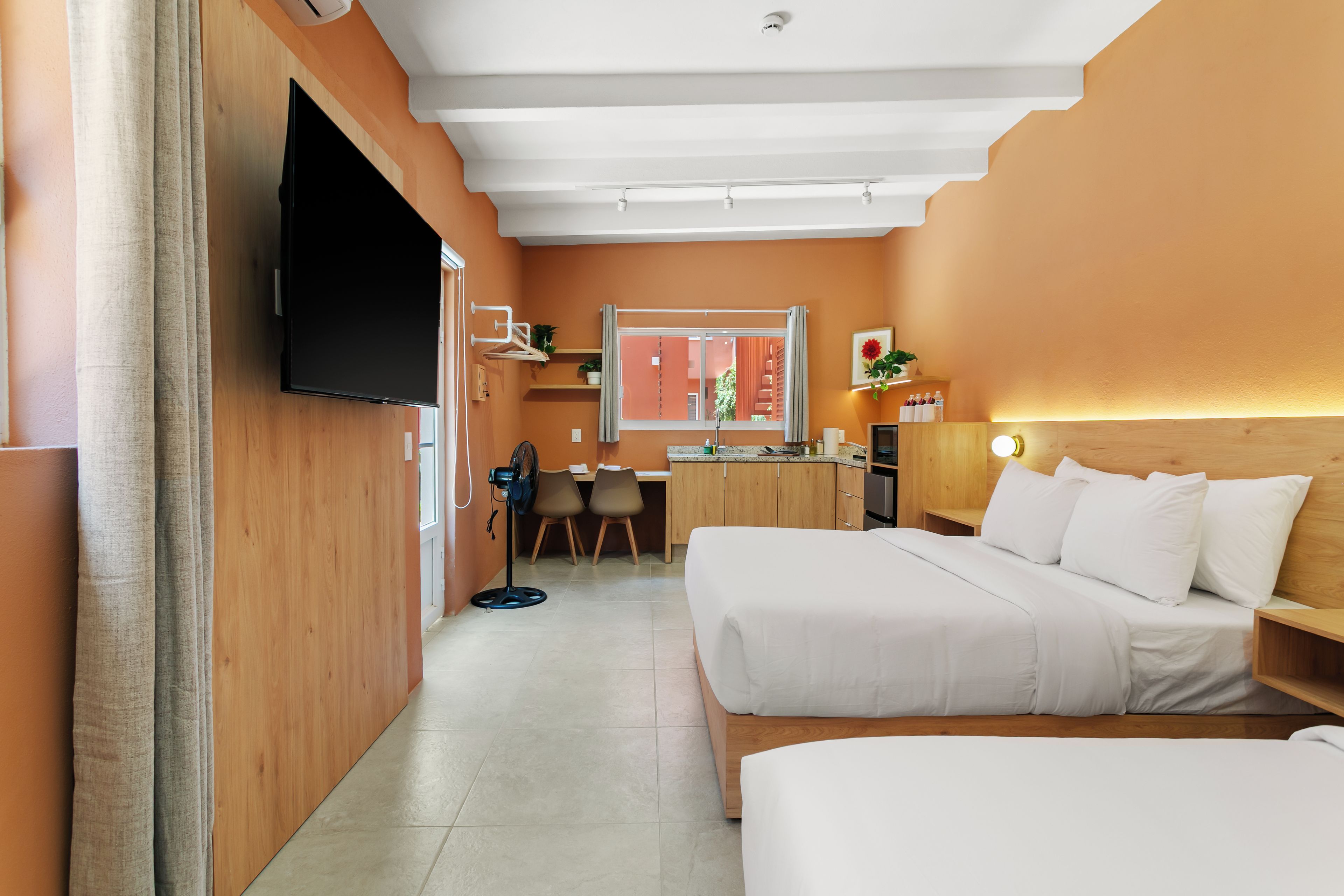 A hotel room with a bed, a desk, and a TV.
