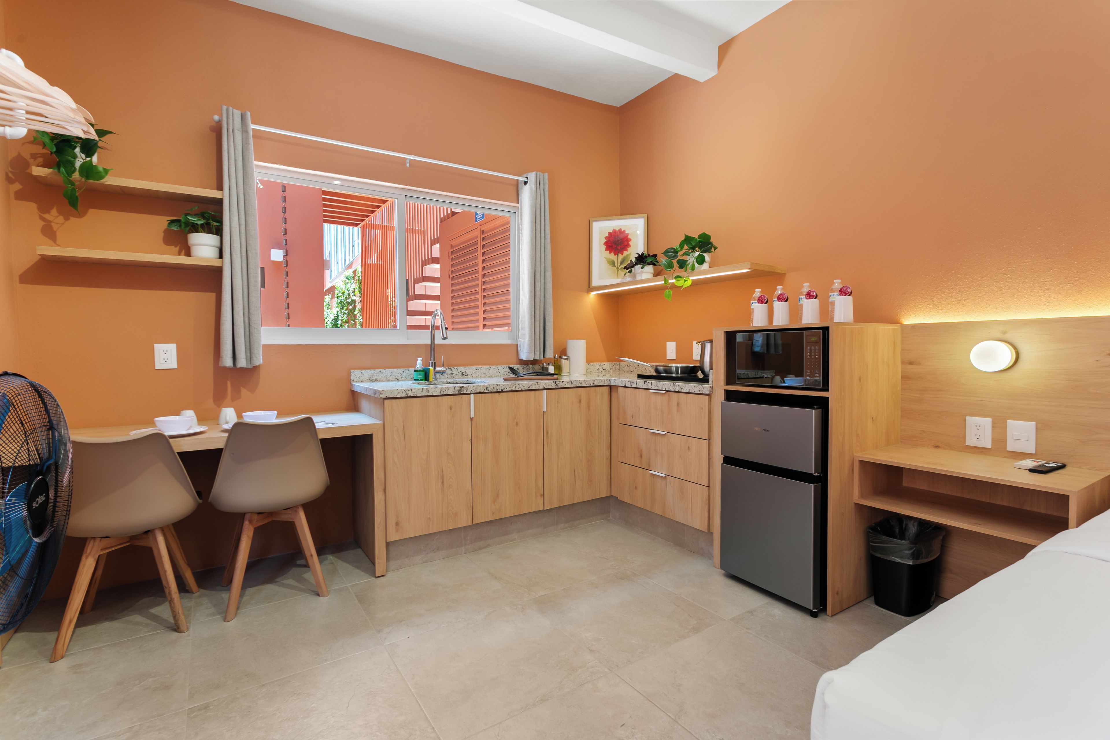Una cocina compacta con comedor, refrigerador y microondas.