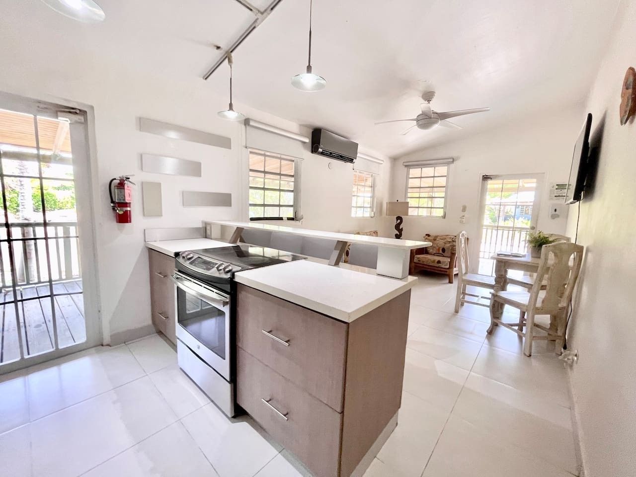 Una cucina moderna con isola centrale, forno integrato e zona pranzo con mobili in legno.