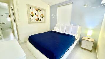 Une chambre à coucher comprenant un lit, une table de chevet, une commode et un élément de décoration murale.