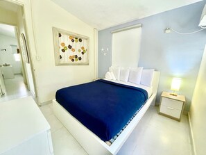 Un dormitorio con cama, mesita de noche y un adorno en la pared.