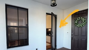 Ein Haustürbereich mit Tür, Fenster und Fußmatte.