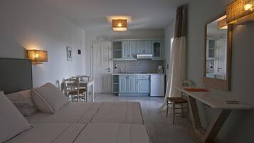 Une chambre d’hôtel moderne équipée d’un lit, d’un bureau, d’une chaise, d’une table à manger et d’un coin cuisine.