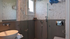 A modern bathroom with a glass-enclosed shower, a white sink, and a toilet. - Double Suite 1 balcony (Naxos)