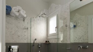 Ein modernes Badezimmer mit einer Duschkabine aus Glas, einem weißen Waschbecken und einer Toilette.