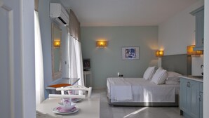 Ein Schlafzimmer mit Bett, Nachttischen, Schreibtisch mit Stuhl, Spiegel und Wandlampe.