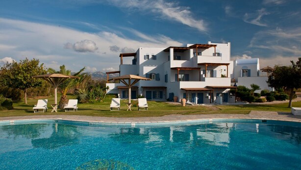 A modern multi-story building with a swimming pool, white exterior, and balconies. - Exclusive Apartments 1st floor (Naxos)