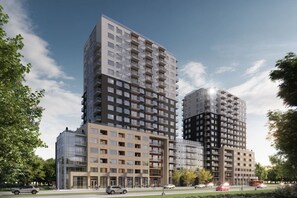 Ein modernes Hochhaus mit mehreren Stockwerken, großen Fenstern und einer Mischung aus Wohn- und Geschäftsflächen.