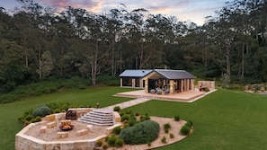 Uma casa moderna com um pátio, lareira e um jardim bem cuidado.