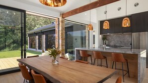 Una cocina moderna con una isla grande, taburetes de bar e iluminación colgante.