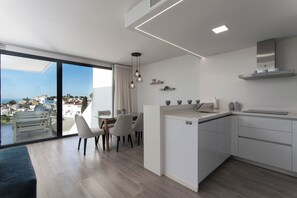 Eine moderne Küche mit Essbereich, großen Fenstern und Blick auf die Stadt.