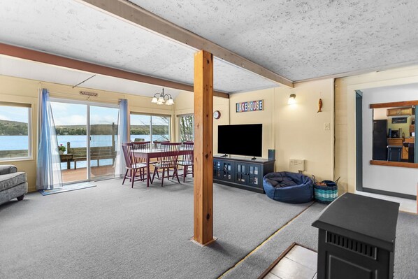 A spacious living area with a dining table, chairs, a TV, and a fireplace.