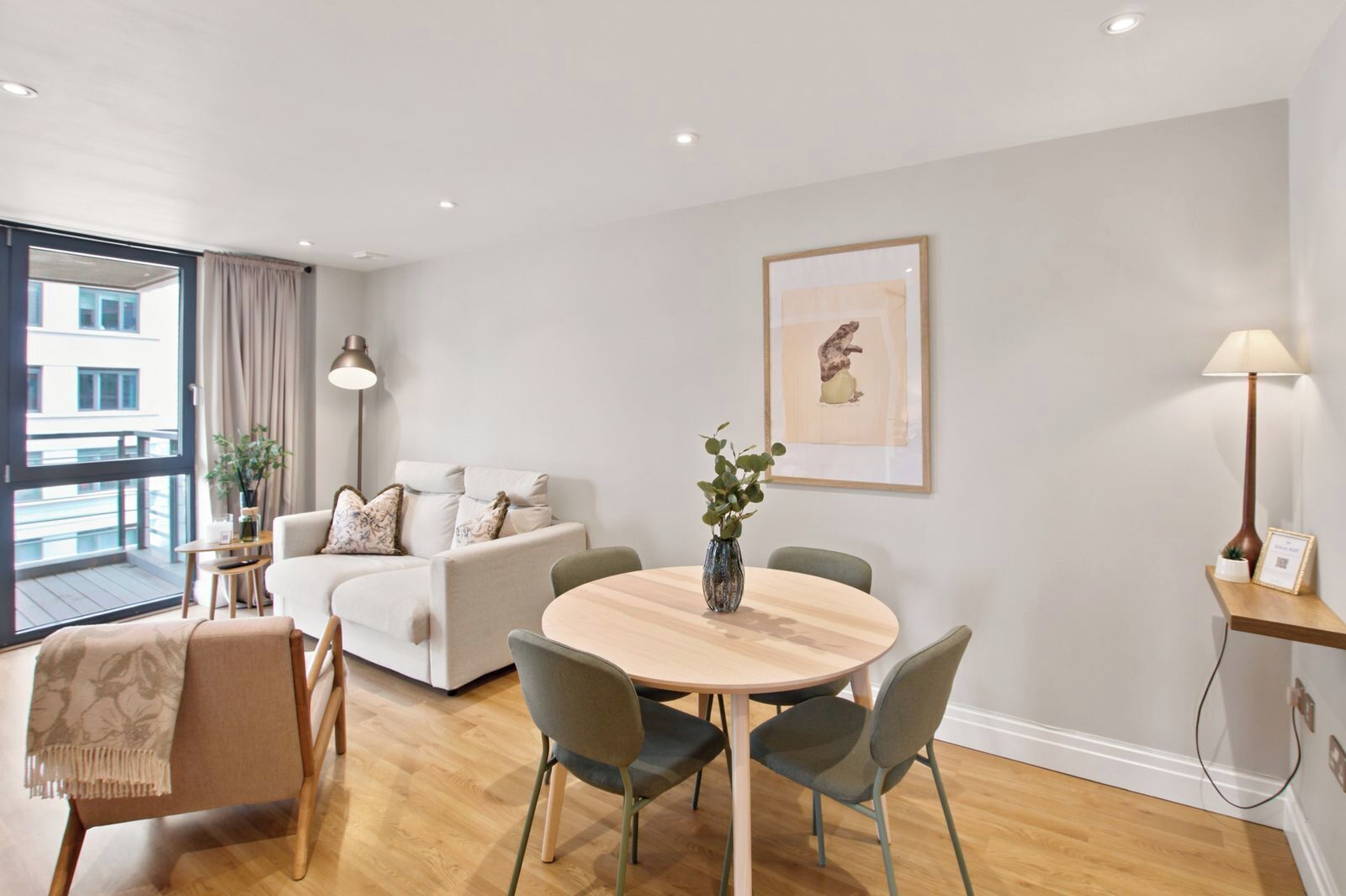 A modern living room with a round wooden table, two sofas, a coffee table, and a dining area.