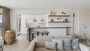 Eine moderne Küche mit Pendelleuchten, einer Bar und einer Sitzecke mit Sofa und Kissen.