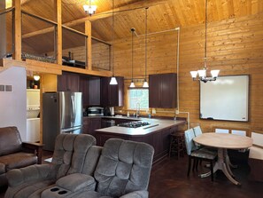 Una cocina amplia con paredes de madera, una isla grande y electrodomésticos modernos.