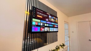 A wall-mounted TV displaying various streaming services and a promotional LG Movie Festival banner. - Modern Entire Apartment- Self Checkin Free Parking (Cowdenbeath)