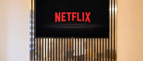 A television mounted on a wall with a Netflix logo displayed on the screen.
