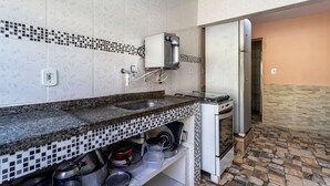 A kitchen with a coffee machine, a sink, and a stove. - Casa com Churrasqueira a 550m da Praia do Saco (Mangaratiba)