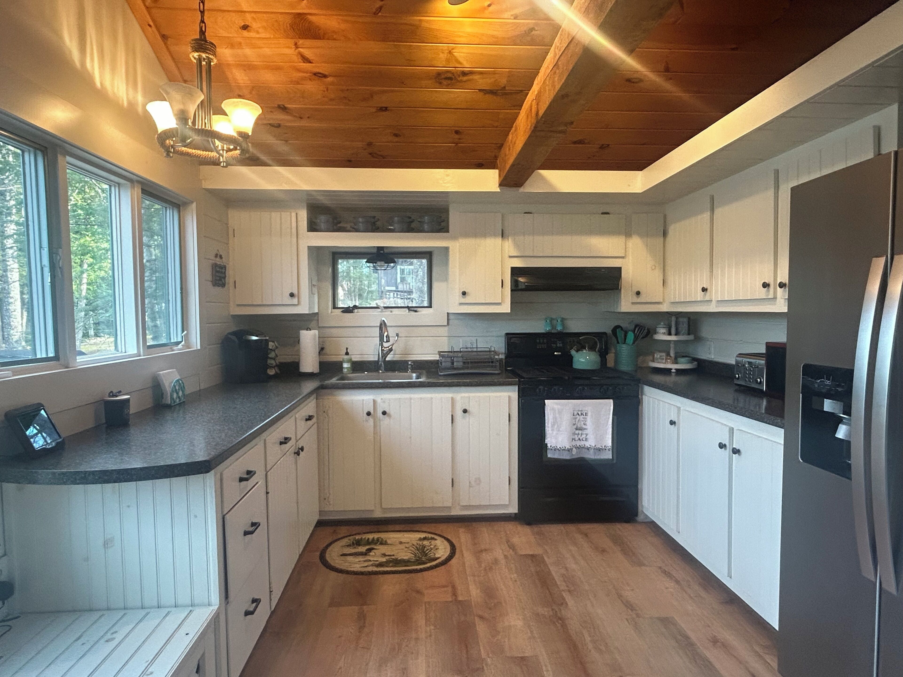 A kitchen with wooden cabinets, a black stove, and a refrigerator.