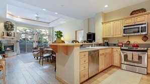 Una cocina moderna con armarios de madera, microondas empotrado y lavavajillas.