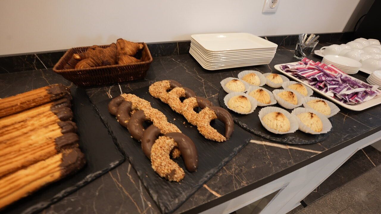 A buffet table with various pastries and desserts.