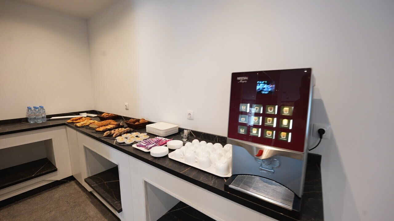A buffet setup with various food items and a coffee machine.