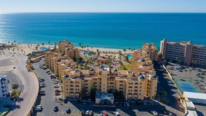 Ein Hotel mit Innenhof, mehreren Etagen und Blick auf den Strand.