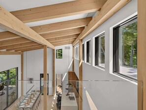 Ein modernes Interieur mit Essbereich, Küche und einer Treppe, die in ein Obergeschoss führt.