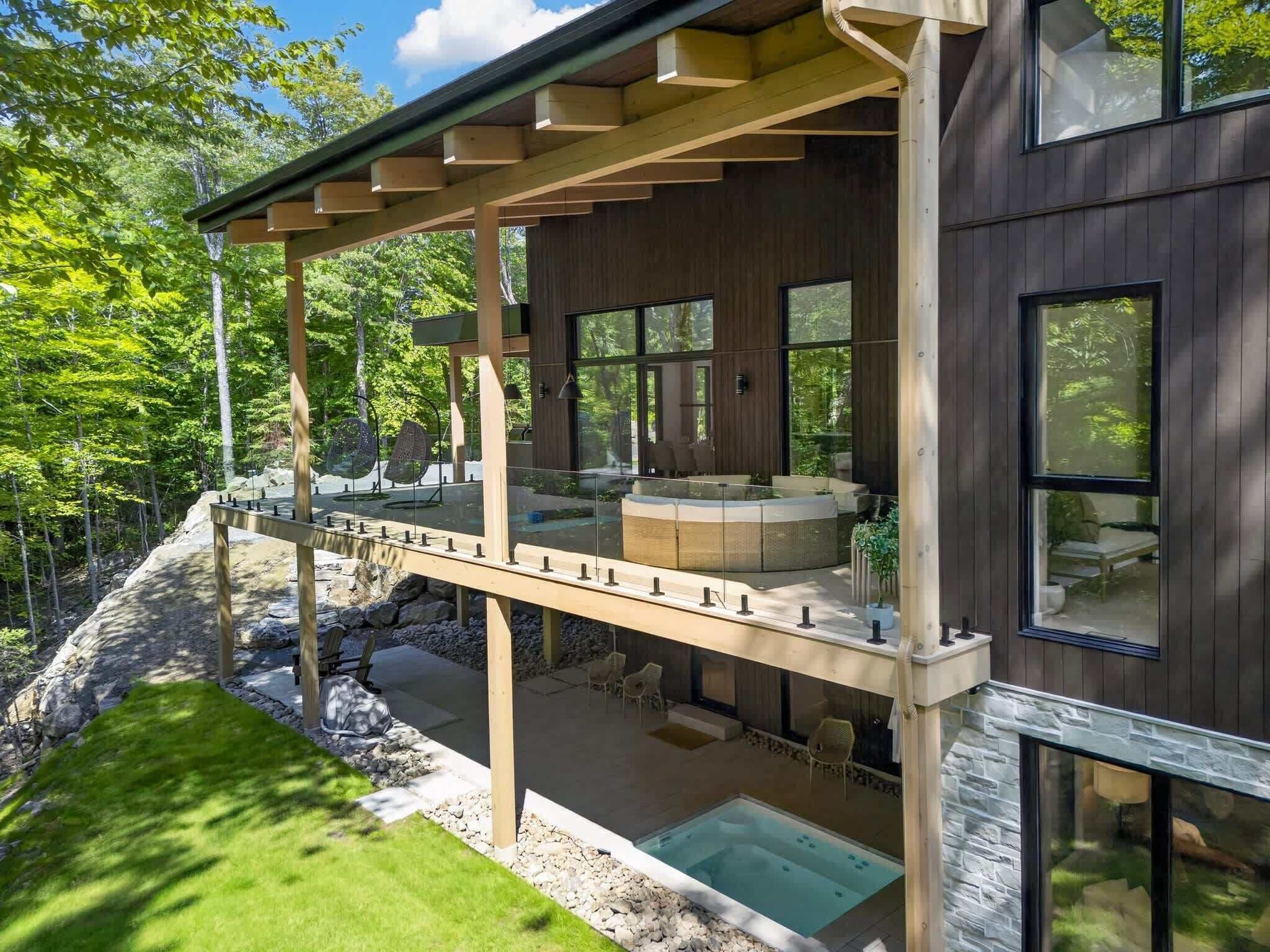 Une terrasse extérieure moderne dotée d’un jacuzzi, d’un espace salon et d’une piscine.