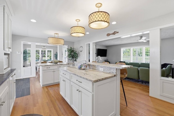 Modern, fully equipped kitchen with sleek finishes, island seating, extra bar space, double door fridge with freezer and a dedicated coffee nook—bright, stylish, and perfect for effortless meals.