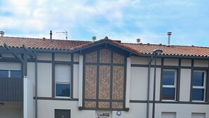 A modern building with a tiled roof, a central entrance, and a paved driveway leading to a crosswalk. - ✨ Appartment 41 m² en rez-de-jardin - Vielle-Saint-Girons (Vielle-Saint-Girons)