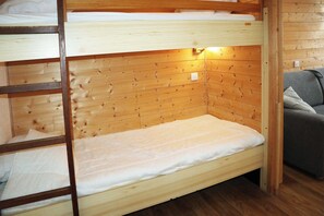 Ein Stockbett mit Holz-Kopfteil und einer Nachttischlampe.