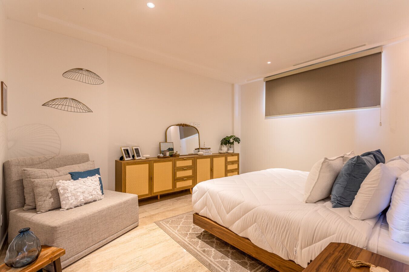 A bedroom with a bed, a sofa, a dresser, and a window.