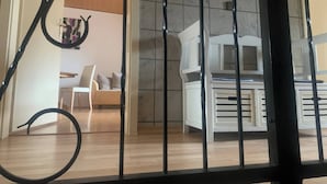 Una habitación con un sofá blanco, un armario blanco y una pared con azulejos.
