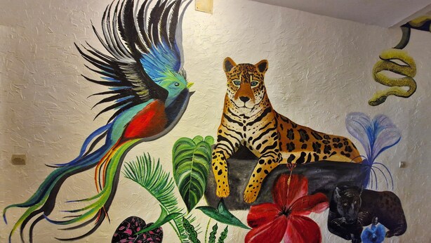Ein Wandbild zeigt einen Vogel, einen Leoparden und verschiedene Pflanzen.