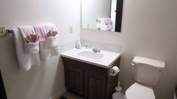 Un baño con lavamanos, inodoro y perchero para toallas.
