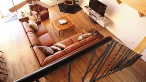 Een moderne woonkamer met een bank, salontafel en een televisie.