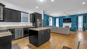 Una cocina moderna con armarios oscuros, una isla central y electrodomésticos integrados.