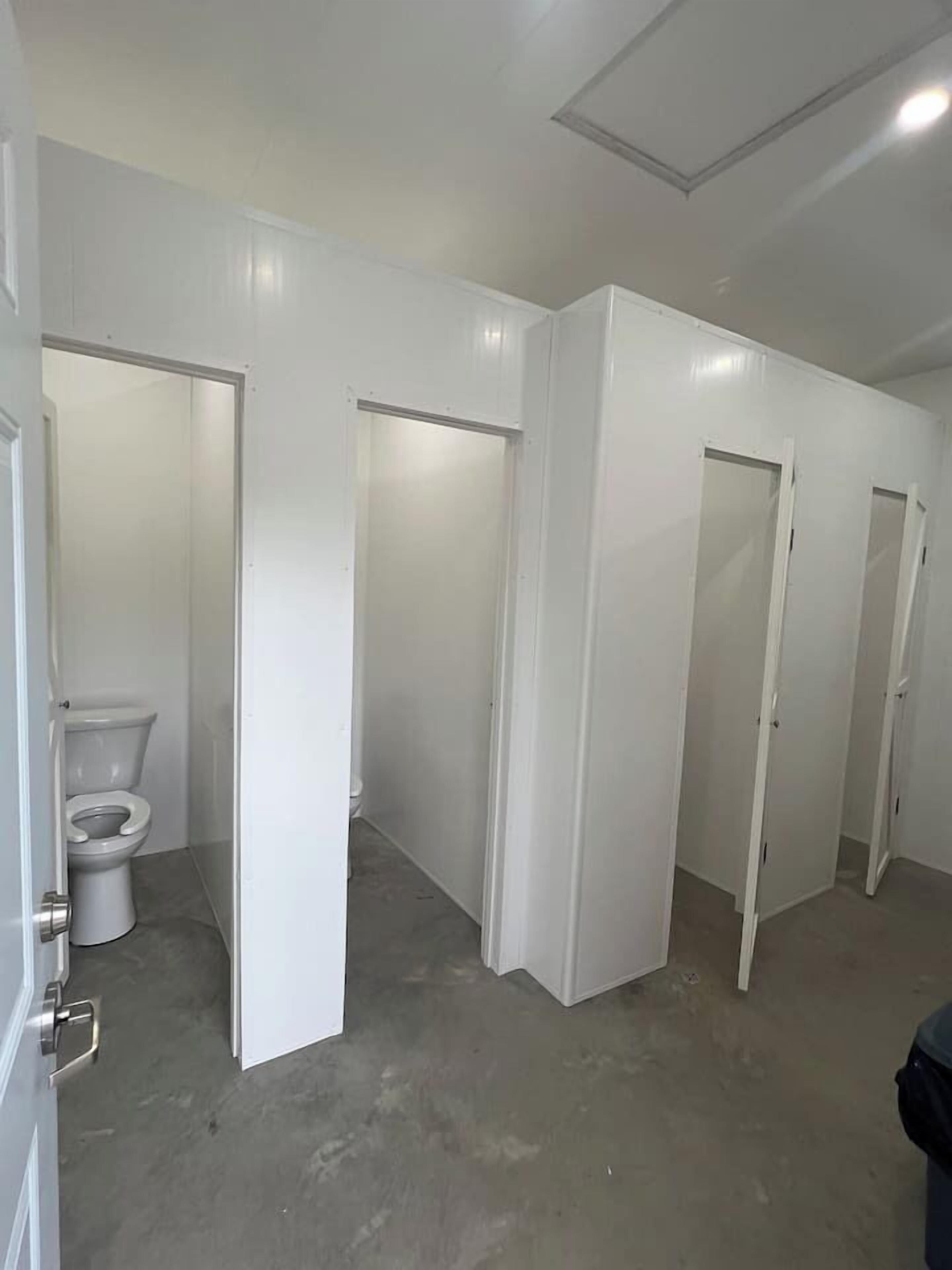 A bathroom with a toilet, a shower stall, and a sink.