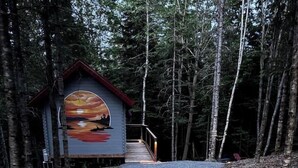 A pathway leading to a cabin with a painted mural on the side.