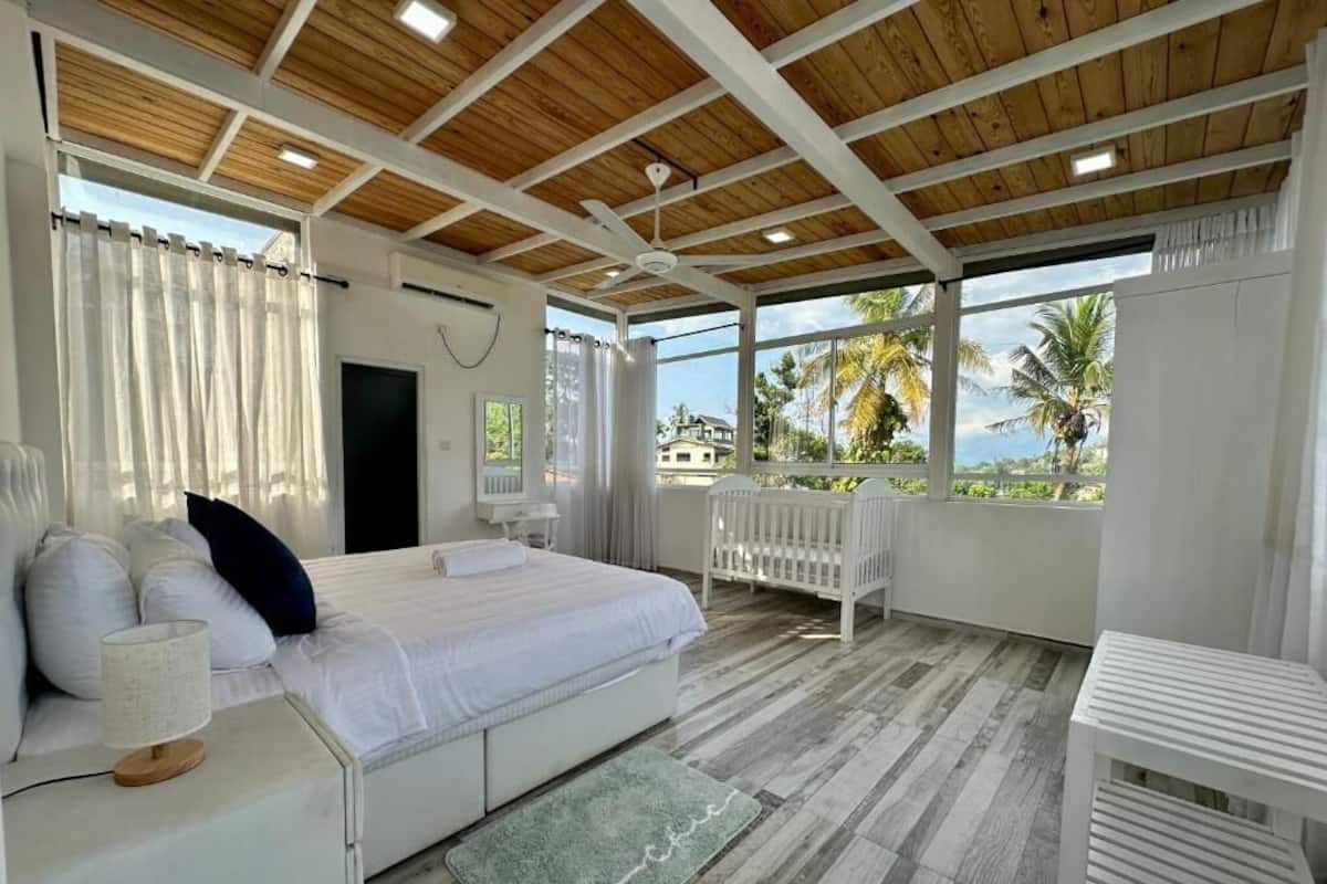 Un dormitorio con cama, mesita de noche y cuna.